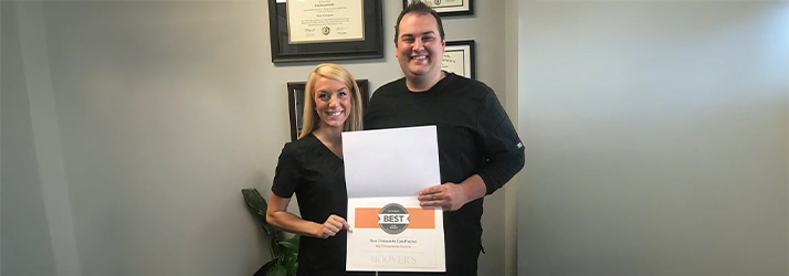 Chiropractor Craig Catalfu Smiling With Staff Member And Award